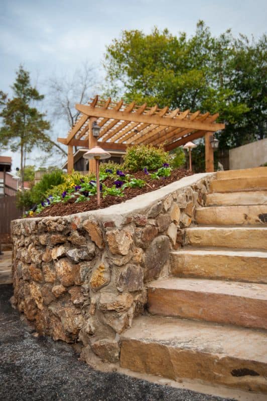 Natural stone staircase with landscaped garden and wooden pergola by John Russell Landscape Architect in a residential yard, showcasing expert landscape and outdoor design.