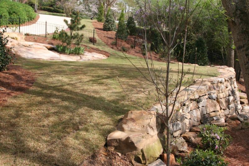 Well-maintained backyard landscape design with rock accents and lush greenery, showcasing expert landscape architecture by John Russell Landscape Architect.