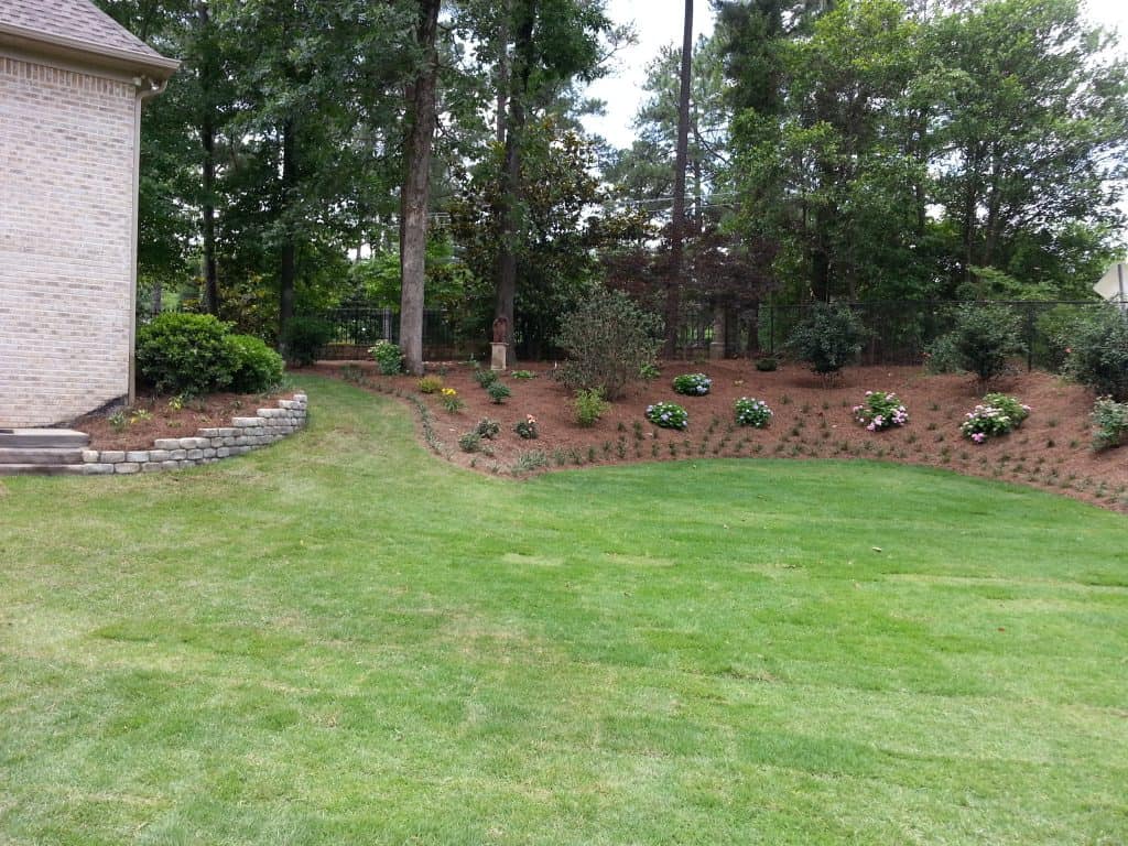 Landscape design by John Russell Landscape Architect with lush lawn and landscaped flower beds, showcasing professional yard and garden landscaping services.