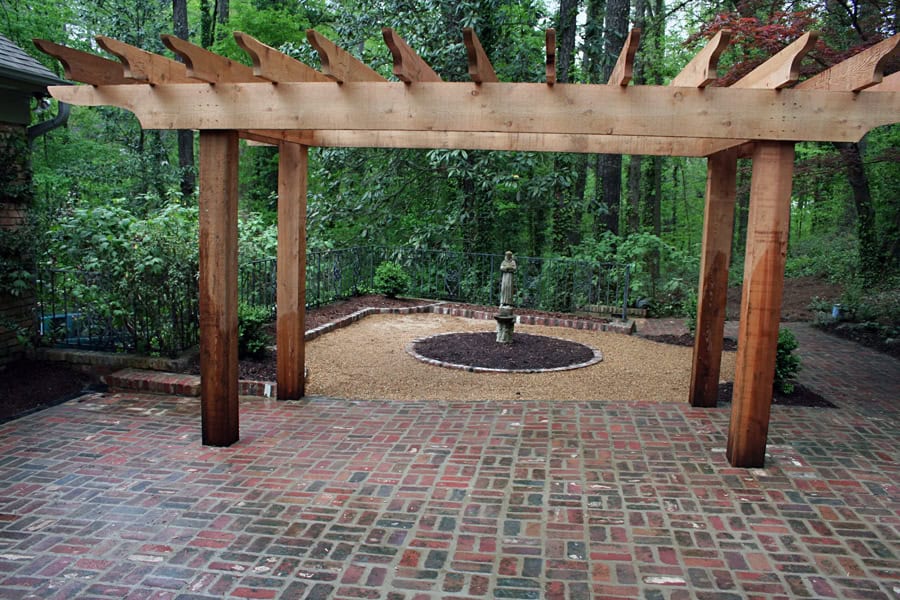 Pergola landscape design with brick patio, garden fountain, and lush greenery - John Russell Landscape Architect.