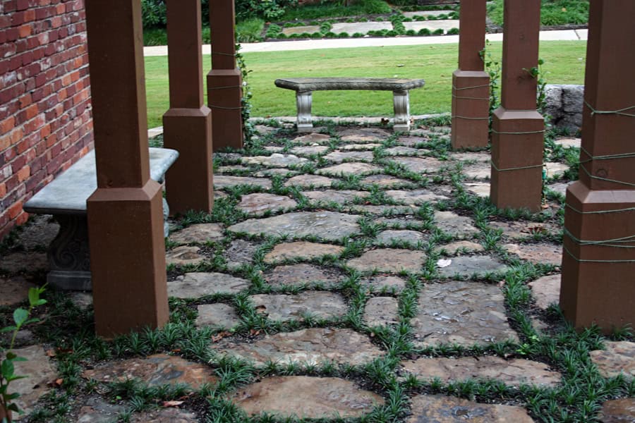 Natural stone pathway with grass accents in a landscaped garden design by John Russell Landscape Architect.