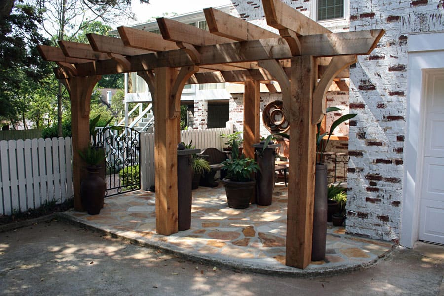 Creekside pergola outdoor hardscape design by John Russell Landscape Architect showing wood structure, potted plants, and patio area.