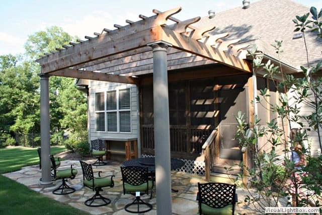 Modern backyard pergola with seating area, outdoor furniture, and lush landscaping, designed by John Russell Landscape Architect for elegant outdoor living.