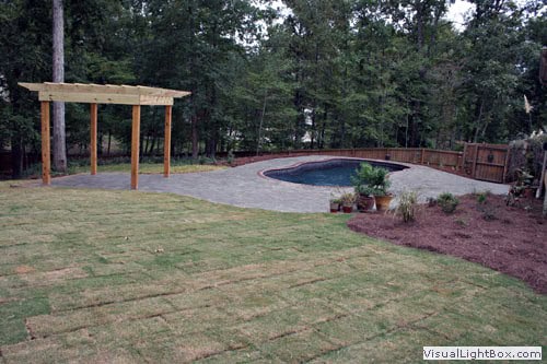 Lush backyard landscape design with patio, pool, and garden features by John Russell Landscape Architect.