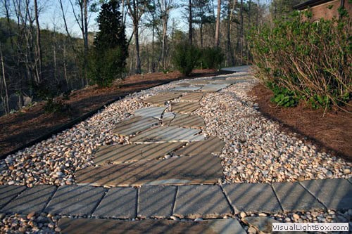 Natural stone garden pathway with landscaped greenery and trees, designed by John Russell Landscape Architect for outdoor aesthetic and functional landscape architecture.