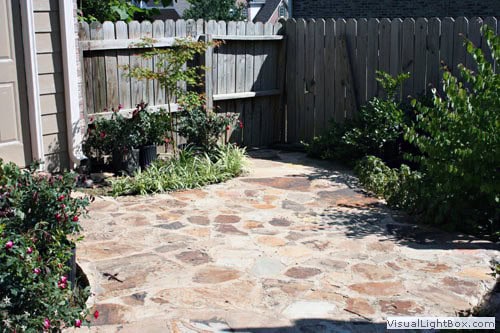 Beautiful stone patio design with lush garden landscaping by John Russell Landscape Architect. Perfect for outdoor living and garden enhancement.
