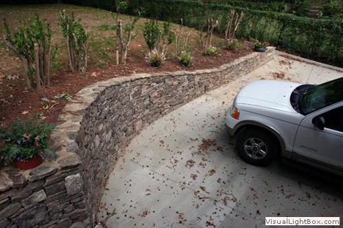 Natural stone retaining wall designed by John Russell Landscape Architect for functional and aesthetic outdoor landscaping solutions.