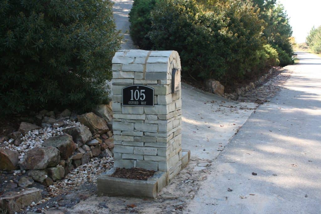 Stone mailbox with landscape design elements in a residential outdoor setting.
