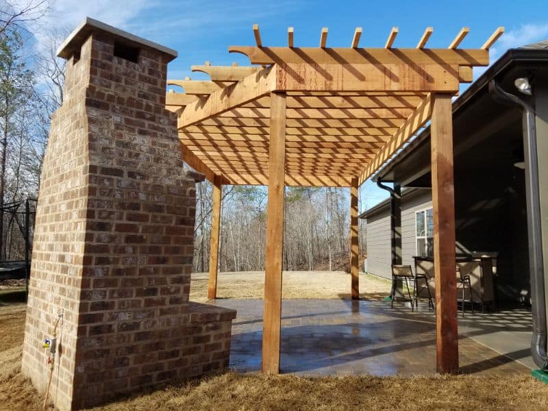Custom wooden pergola under construction in backyard, designed by John Russell Landscape Architect, showcasing outdoor living space and landscape design.