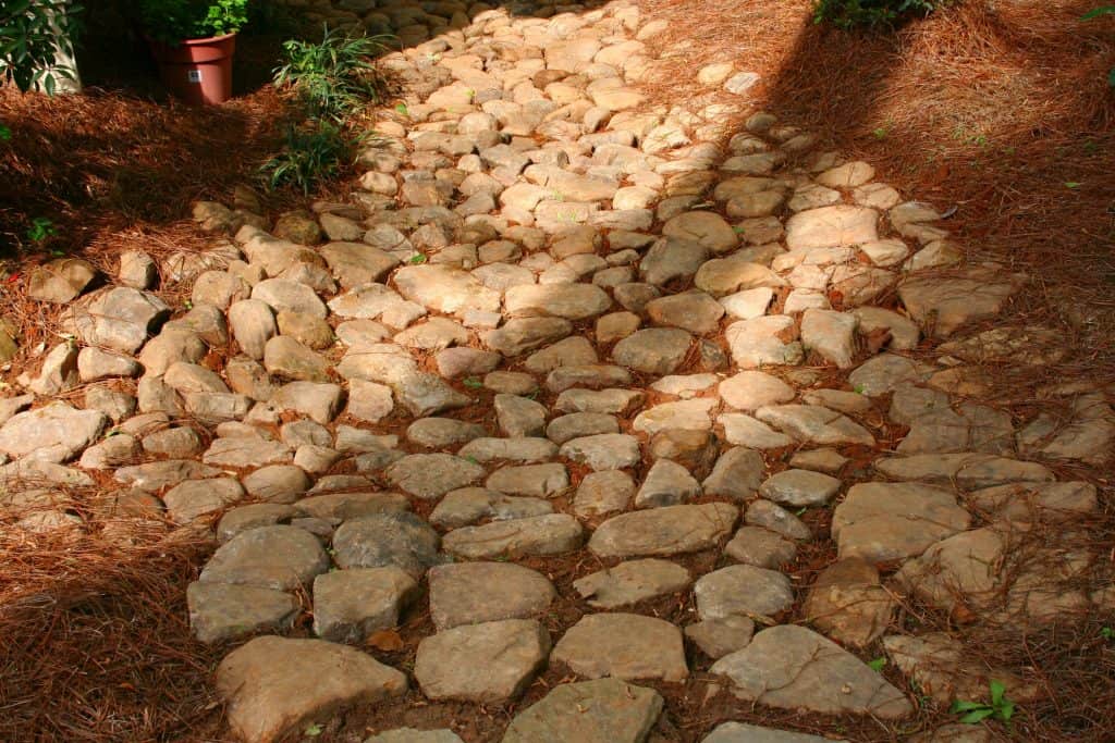 Rugged stone pathway with large natural rocks, landscape design emphasizing durable materials and natural aesthetics, created by John Russell Landscape Architect for outdoor gardens and walkways.