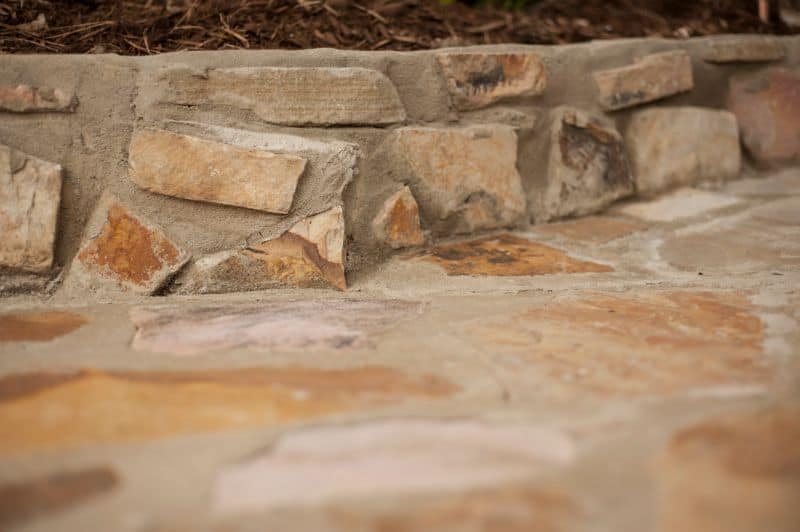 Weathered natural stone and brick landscape edging for garden or pathway design, showcasing craftsmanship in stonework and landscaping.
