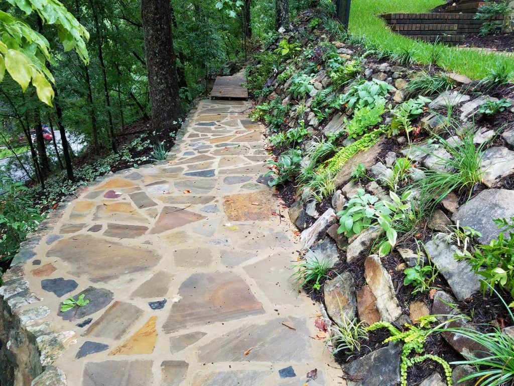 Natural stone landscape pathway with lush greenery, perfect for garden design and outdoor living spaces, showcasing expert landscape architecture and hardscape craftsmanship.