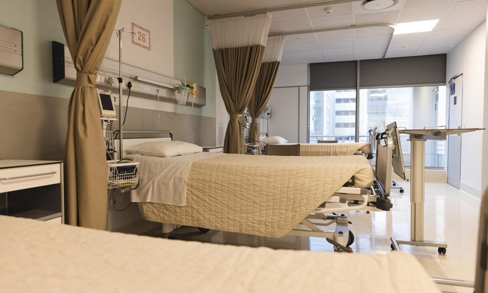 Modern hospital patient rooms at Kalyan Hospital with beds and advanced medical equipment.
