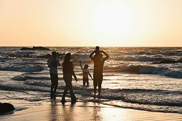 Famille profitant du coucher de soleil sur la plage en Guadeloupe lors d'une activité KaraïJet