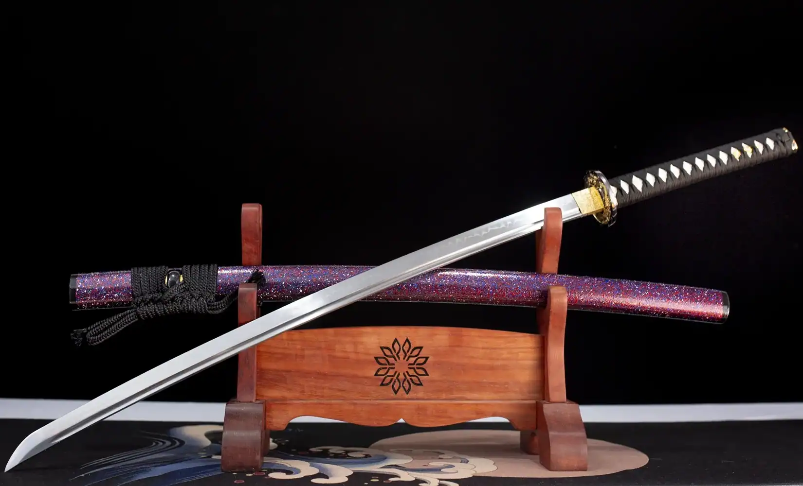 Hand-forged katana with curved blade on stand
