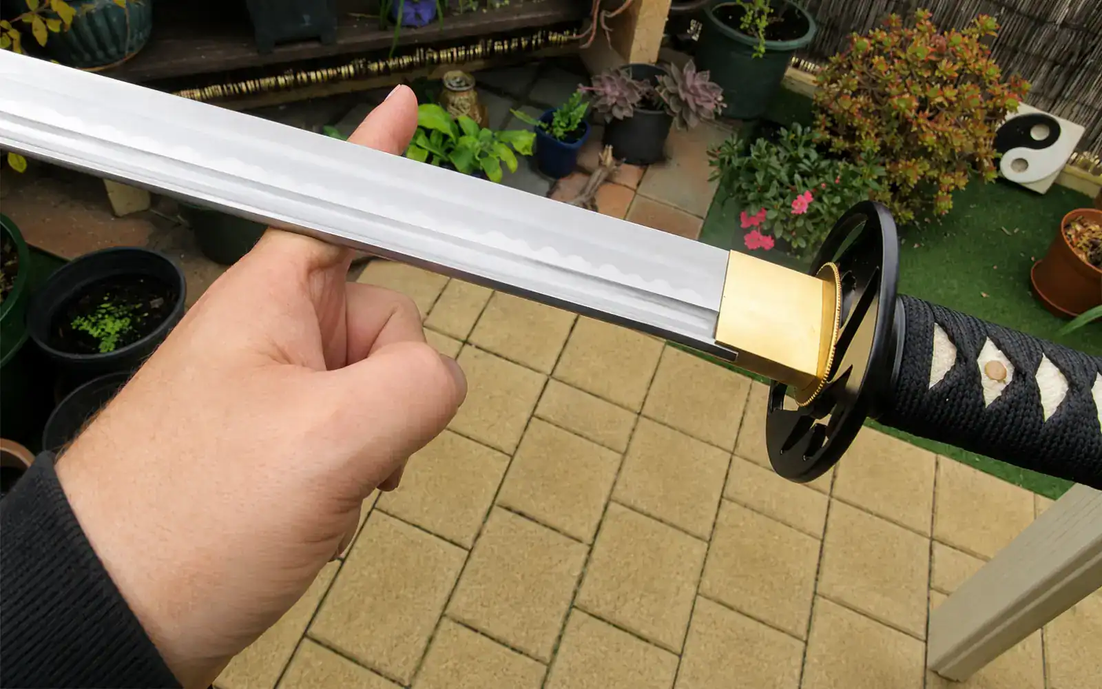 Hand holding a katana outdoors