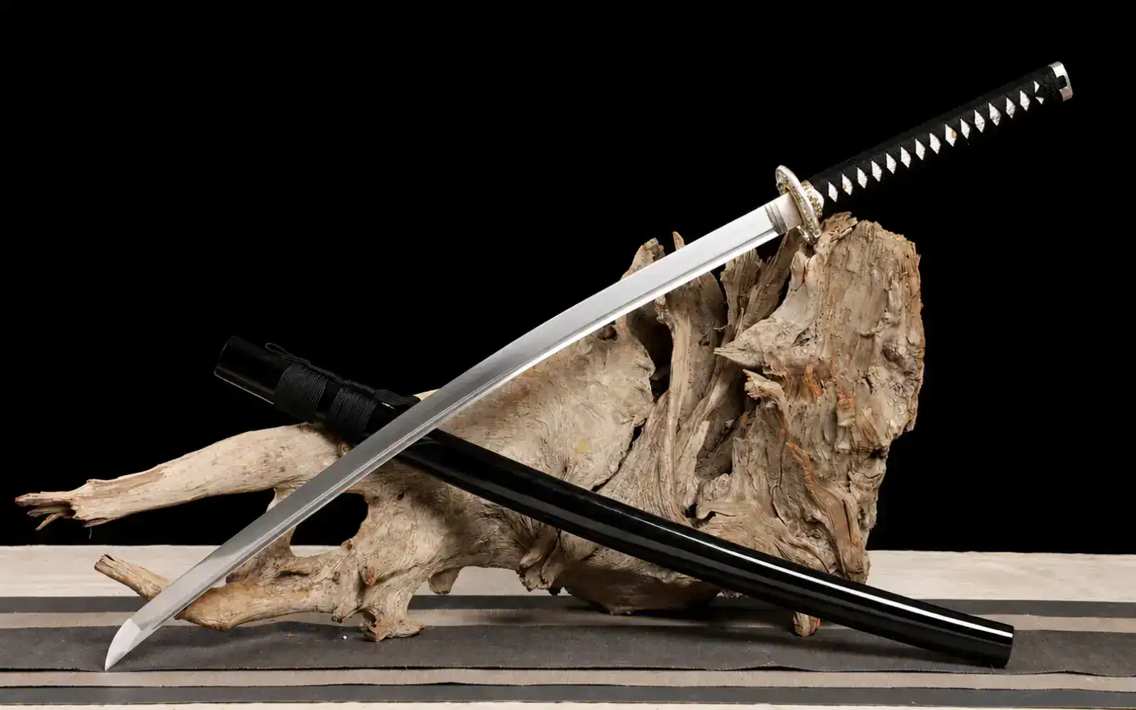 Katana displayed on wood against black