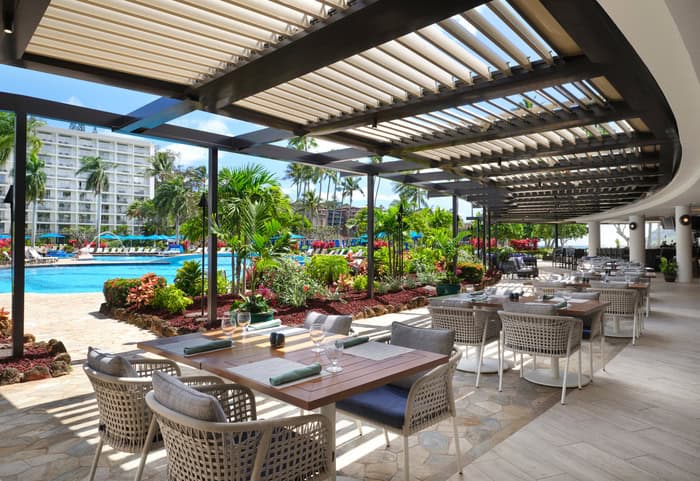 Outdoor dining area at the beach club, featuring tables and chairs with ocean views at the Kauai Resort.