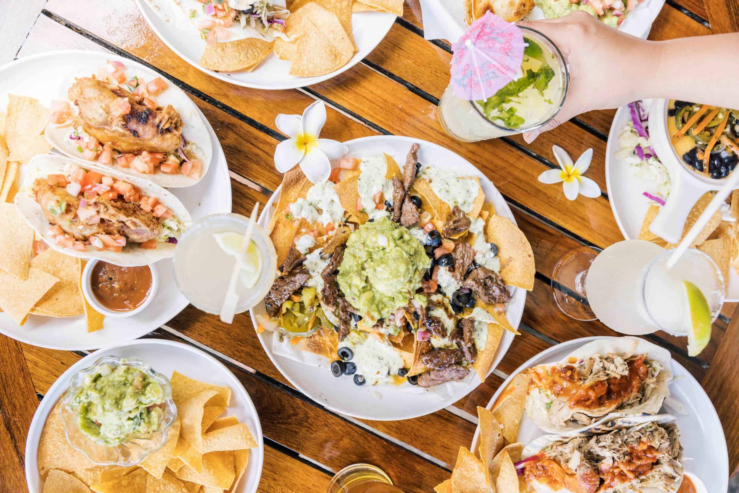 A table set with various plates of food and drinks, showcasing a colorful and abundant spread for a gathering.
