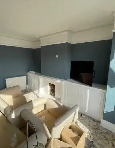 Beautiful living room with blue painted walls, white moldings, and a fireplace, perfect for relaxing.