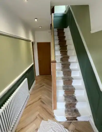 Interior staircase with green walls and wooden steps under renovation.