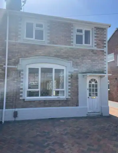 Beautiful brick house with white window frames and front door, showcasing professional exterior deco.