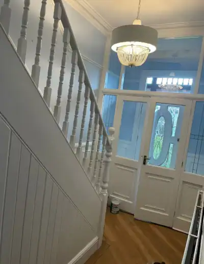 Interior staircase with white spindles and handrail leading to upper floor.