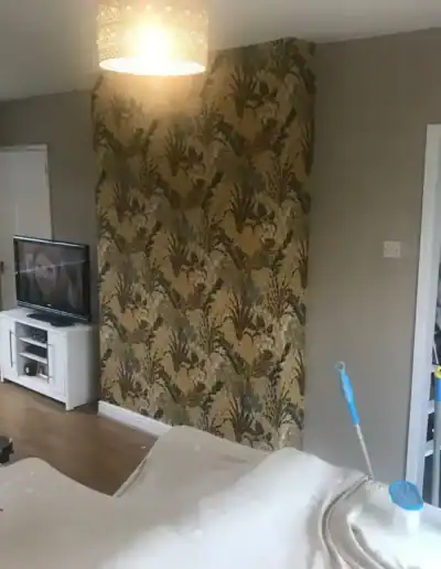 Modern living room with feature wallpaper wall and neutral decor by KB Decorating.