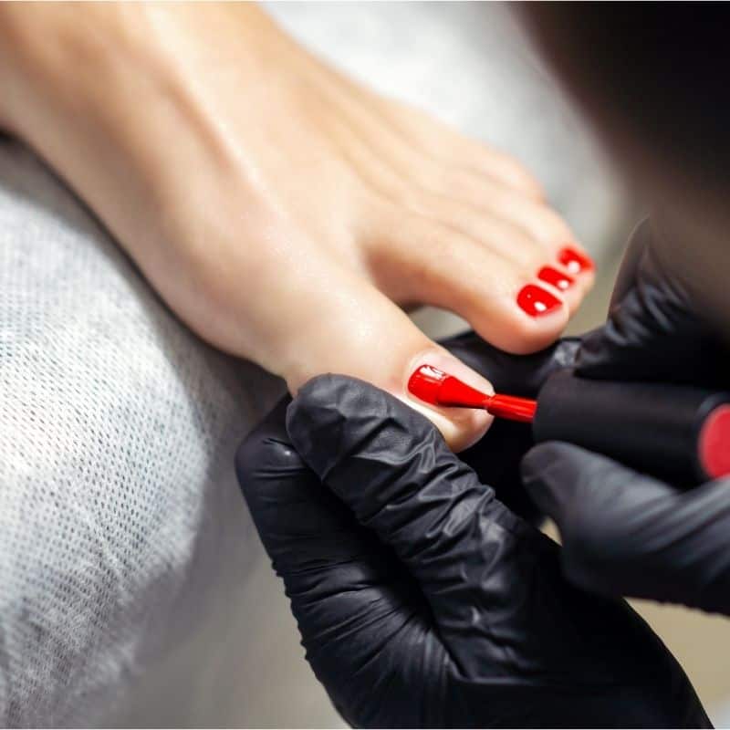 Nagelmodell wird rot lackiert, professionelle Maniküre, Nagelstudio, Beauty, Pflege.