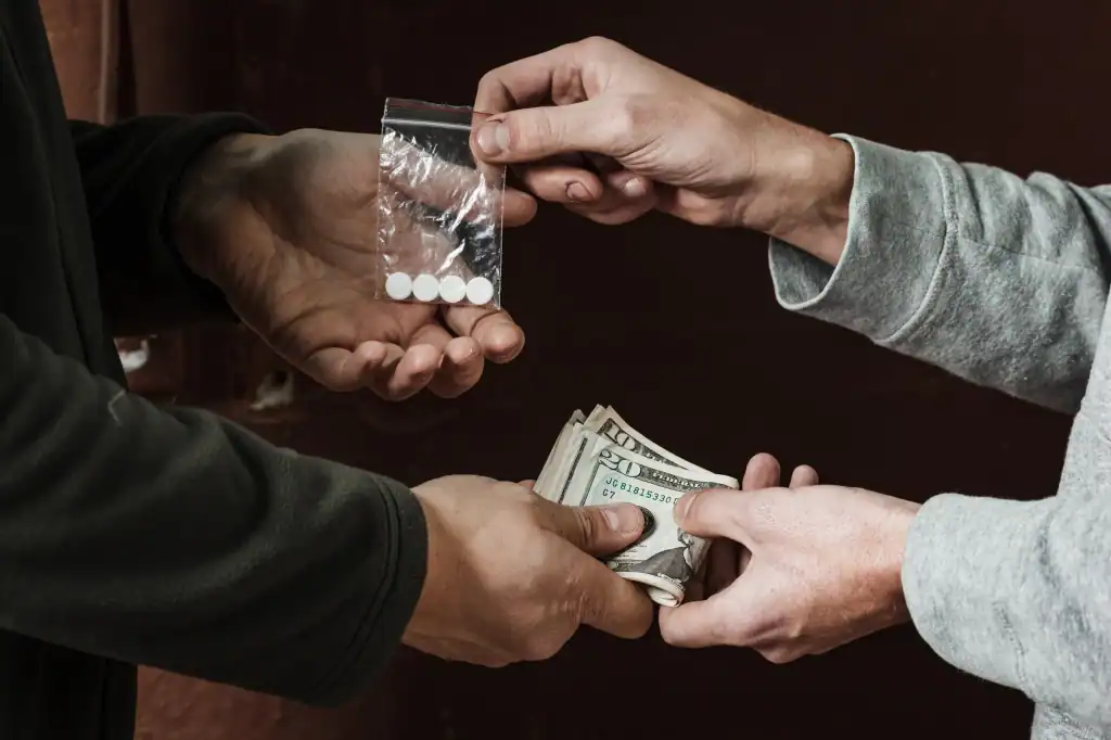 Illicit drug exchange with cash, criminal activity, police investigation, illegal drug sale, law enforcement, criminal justice, drug trafficking, law office of Benjamin Arnold, legal representation for criminal defense, Kansas City DUI legal expert.