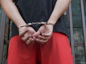 Handcuffed person with hands behind back, legal issues, criminal arrest, police custody, justice system, law enforcement, defendant, detention, law office of Benjamin Arnold.