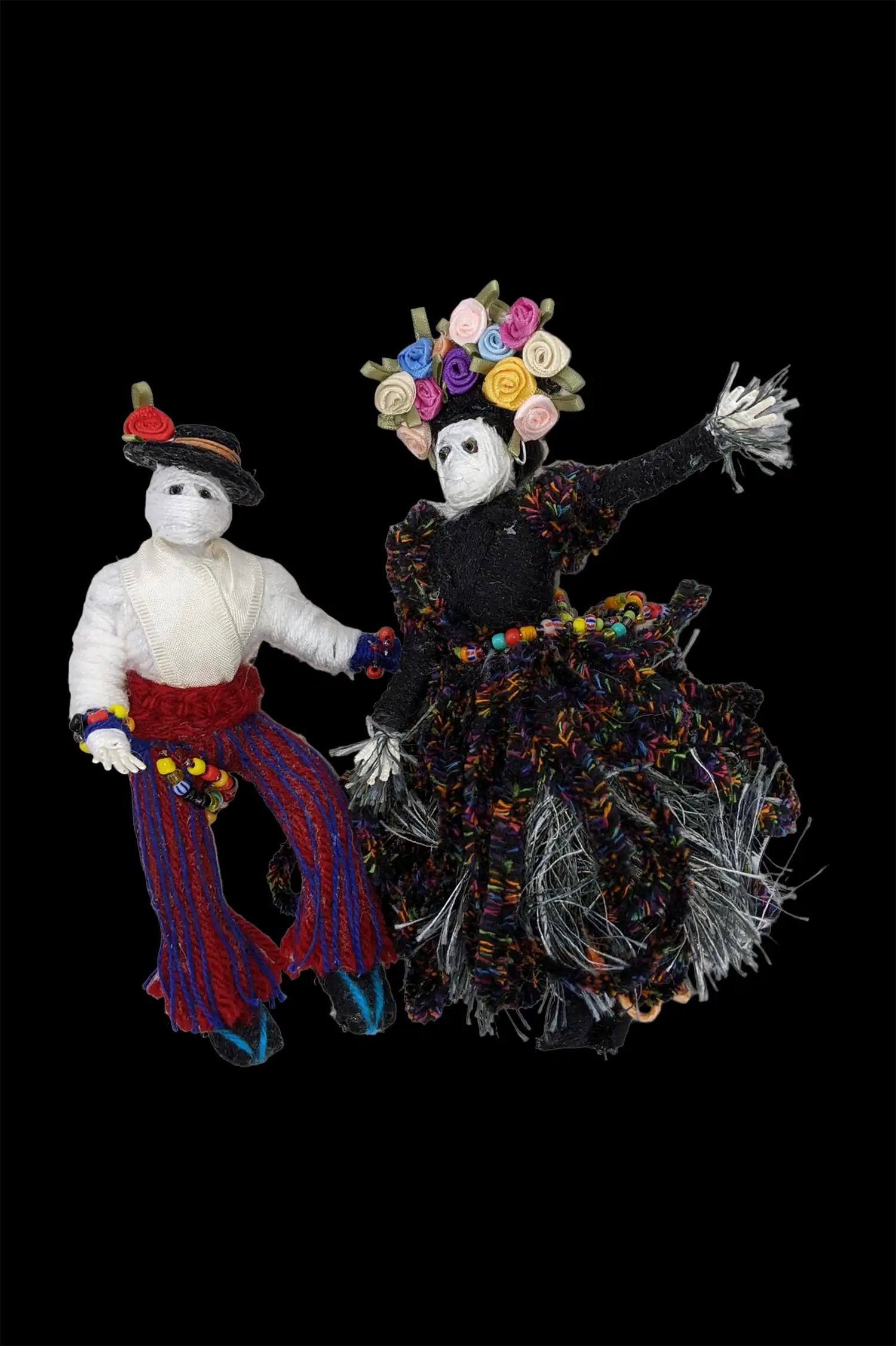 Handmade Day of the Dead skeleton dolls, a male and female couple, adorned with vibrant floral decorations.