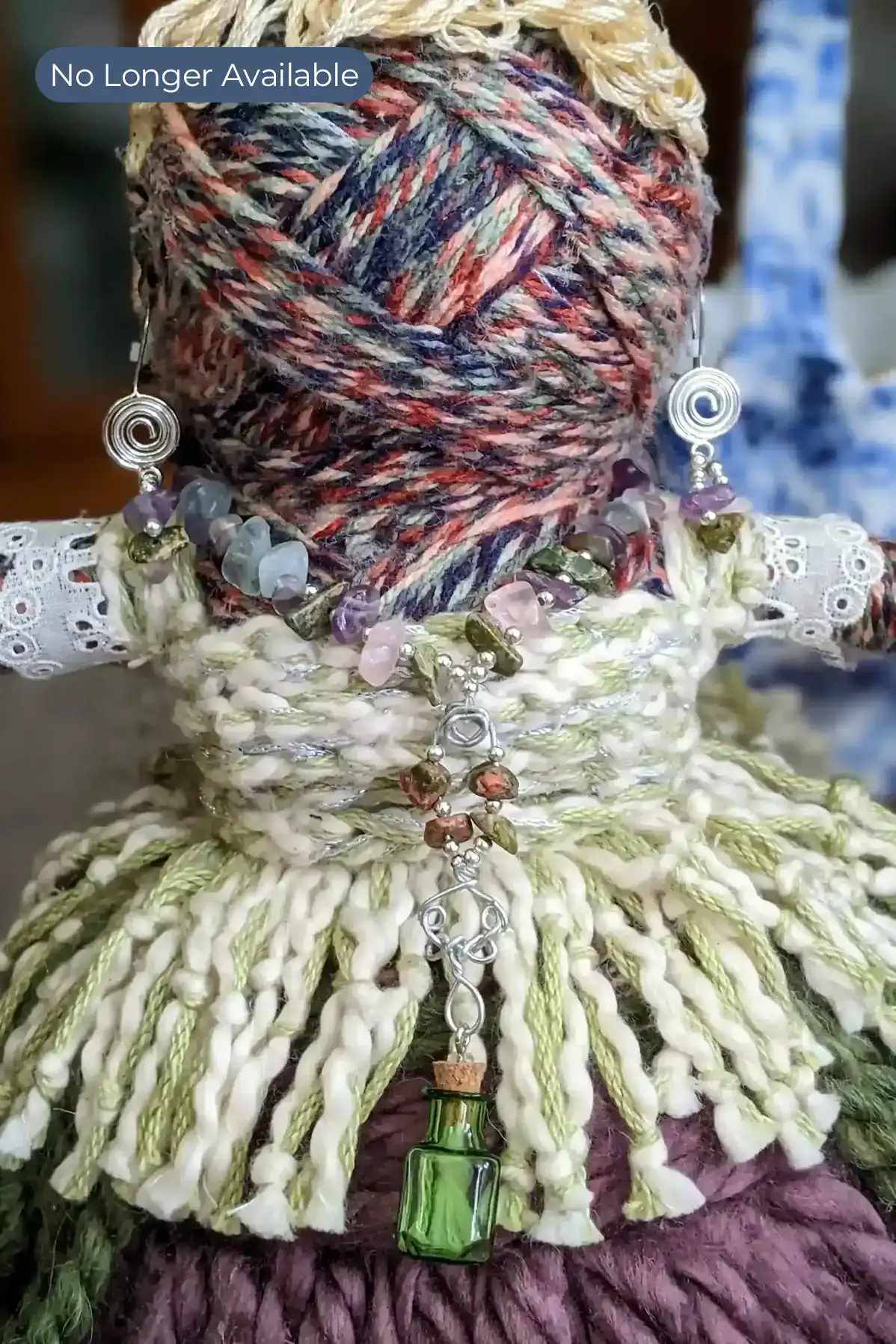 Close-up of Leela the health and wellness art doll from head to hips, showcasing her gemstone jewelry and a small green bottle pendant for jasmine aromatherapy oil. This is a portfolio doll, no longer available for sale.