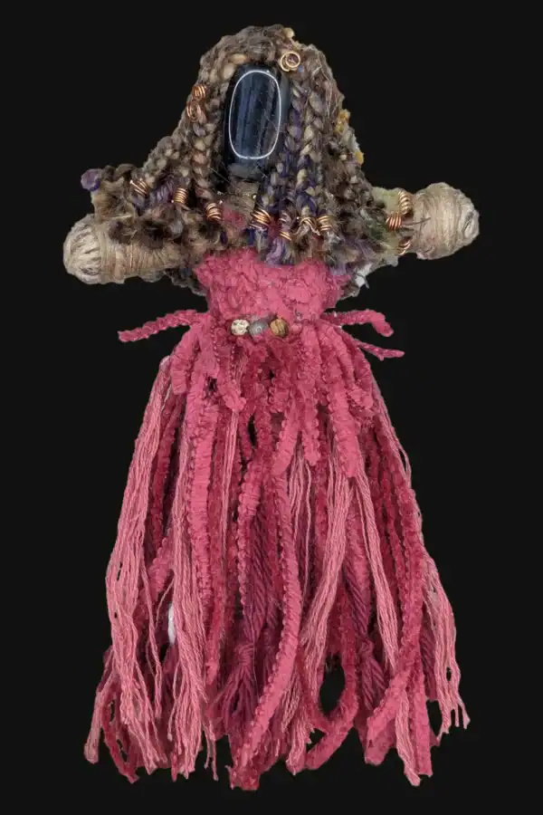 Absynthe Healing Art Doll featuring a Blue Tiger’s Eye head, Selenite feet, multicolored yarn hair, and a vibrant pink skirt, shown against a black background.