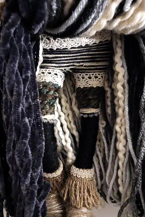 Close-up of Hannah the Kitchen Witch’s boots, black stockings, lace trim, and striped boy-shorts beneath her velvety skirt.