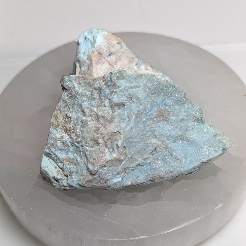 Amazonite on a selenite charger. It empowers you to honor the death of a part of yourself.