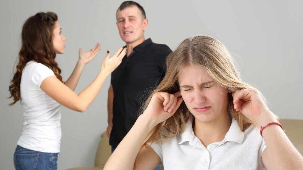 Teen girl covering ears while parents argue in background, depicting family conflict as a primary cause of adolescent depression.