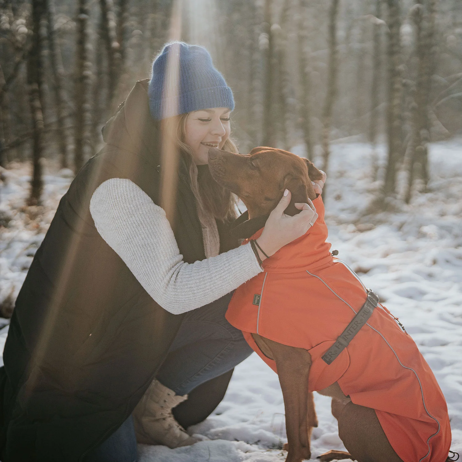 Hundefreundliche Frau mit Golden Retriever in Winterwald, gemeinsame Zeit, Hundeschutzmantel, outdoor Hundeshop, Kiezhund Hundeshop.