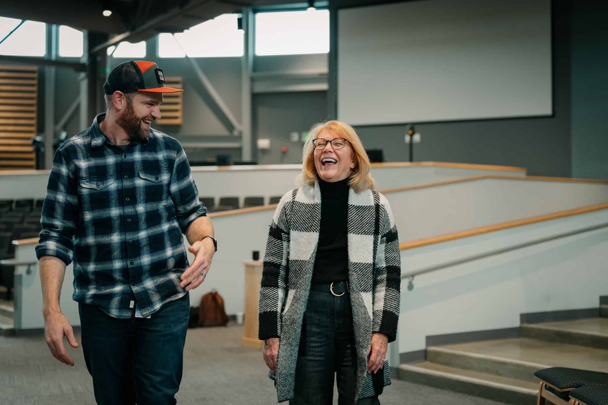 Two people smiling and engaging in a friendly conversation in an office