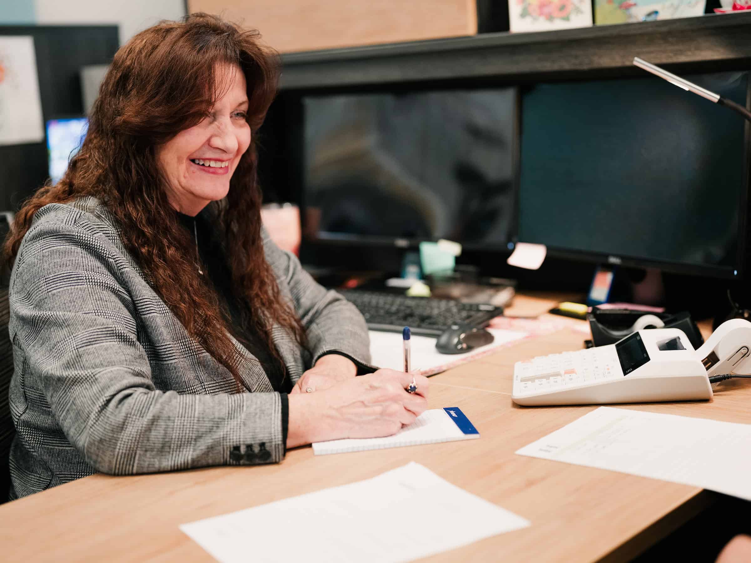 A professional woman sitting at a desk in an office environment