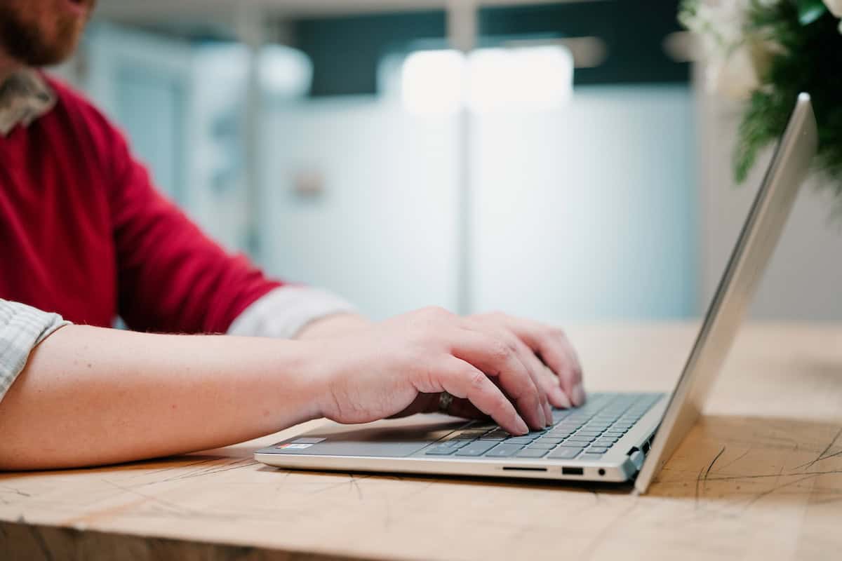 A closeup of someone typing on a laptop