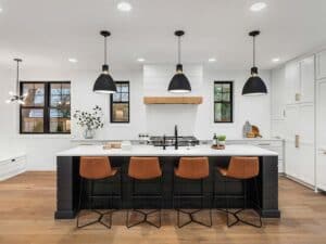 Bright modern kitchen with black island and warm brown barstools, ideal for kitchen remodeling.
