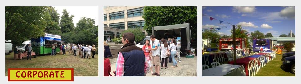 Outdoor corporate catering event with food trucks and seating areas in a park setting.