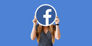 Facebook logo held by woman representing social media marketing for catering services.