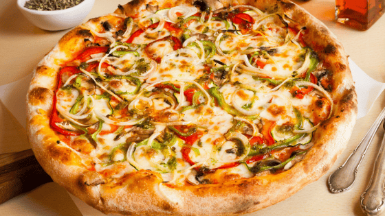 Delicious vegetable pizza with cheese, peppers, and onions for catering and delivery services.
