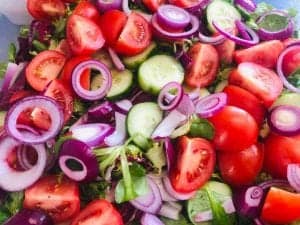 Fresh mixed salad with tomatoes, cucumbers, and red onions for catering and events.
