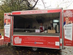 Fresh breakfast van serving hot meals at outdoor event in autumn.