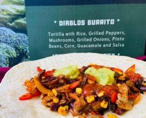 Vegan burrito with rice, grilled peppers, mushrooms, and guacamole for catering events.