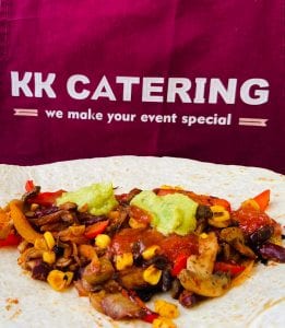 Fresh Mexican vegetable wrap with colourful peppers, corn, and guacamole on a flour tortilla.