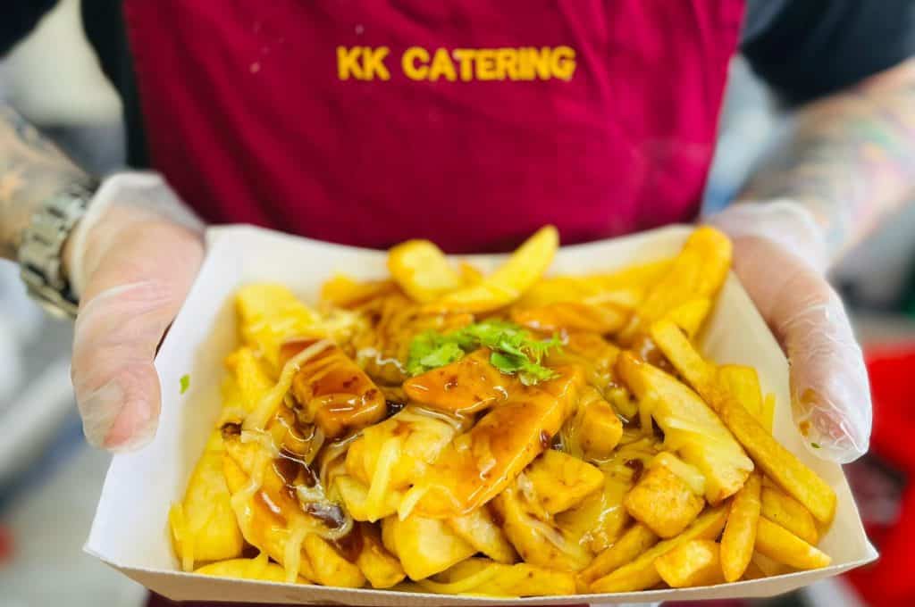 Delicious Chinese takeaway meal with fries and sweet and sour chicken, served in a KK Catering branded container.